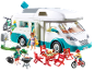 Camping-car jouet avec figurines, vélos et meubles de pique-nique.