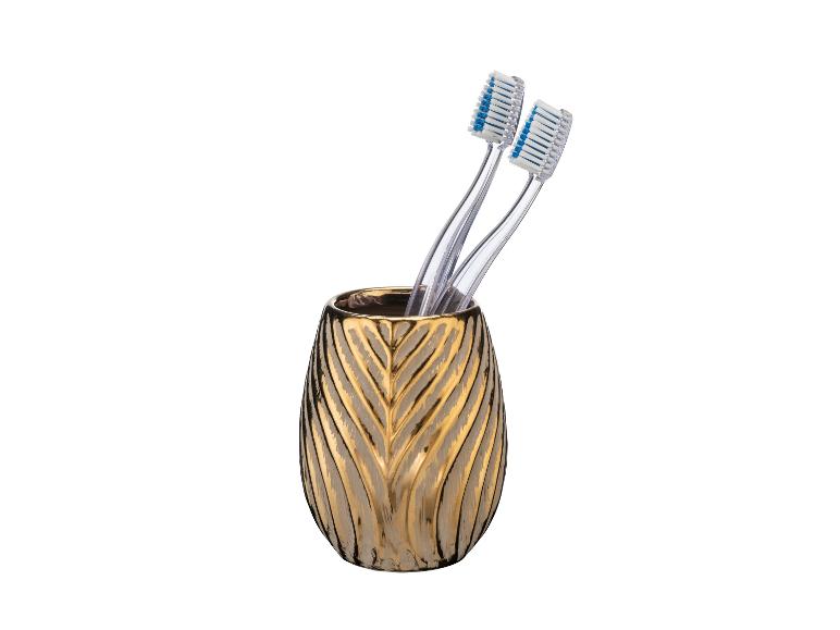 Deux brosses à dents dans un gobelet doré.