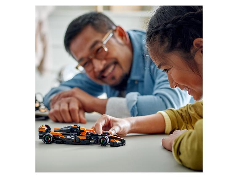 Un enfant joue avec une voiture de course LEGO McLaren Formule 1.