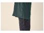 Détail d'une veste de pluie vert foncé portée sur un jean foncé.