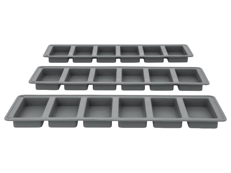 Trois moules à glaçons en silicone gris avec six compartiments rectangulaires chacun.