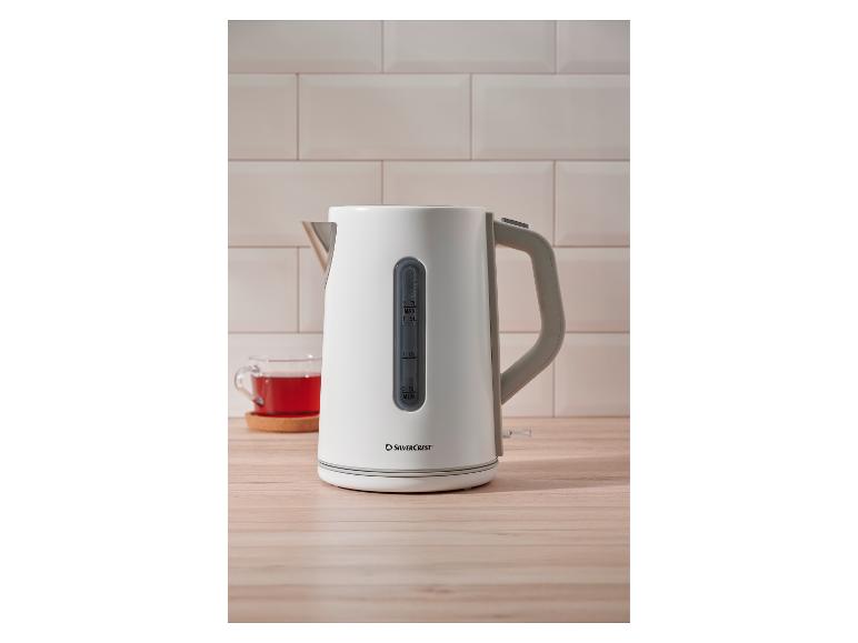 Bouilloire SilverCrest sur une surface en bois avec une tasse de thé.