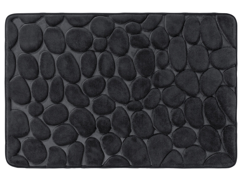 Un tapis de bain noir avec un relief de pierres rondes.