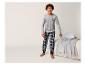 Un garçon avec un t-shirt gris avec le logo NY et un pantalon à carreaux