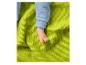 Pied de bébé en pyjama bleu sur une couverture gaufrée verte.