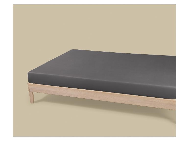Drap-housse gris sur un cadre de lit en bois