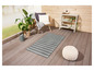 Un tapis gris rayé sur une terrasse en bois