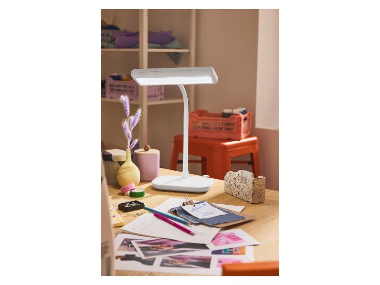 Lampe de bureau LED blanche sur un bureau en bois avec des accessoires de couture.