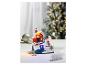 Une décoration de Noël avec une maison, un sapin et des figurines dans la neige.
