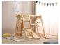 Aire de jeux intérieure en bois avec balançoire, toboggan et échelle de corde dans une chambre d'enfant.