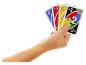 Une main tient plusieurs cartes de jeu colorées avec des chiffres et des symboles.