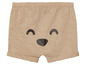 Short beige avec un visage souriant.