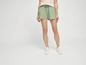 Femme en short vert et baskets blanches