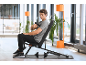 Homme utilisant un pistolet de massage assis sur un banc de musculation dans une salle de sport moderne.