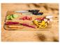 Couteaux de cuisine et légumes frais coupés sur une planche à découper en bois.