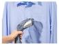 Main tenant un défroisseur vapeur pour défroisser une chemise bleu clair