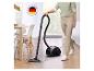 Aspirateur traîneau noir sur un sol en bois, avec une personne qui le tient et du texte 'MADE IN GERMANY'.