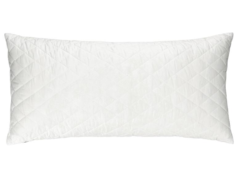 Un oreiller rectangulaire blanc matelassé.