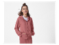 Une femme porte un ensemble de survêtement rose à capuche.