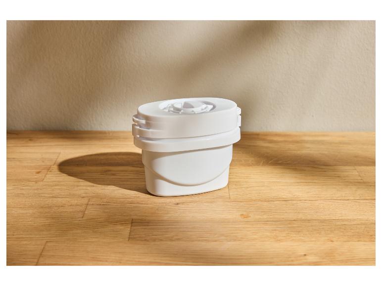 Filtre à eau blanc sur une surface en bois avec un mur beige en arrière-plan
