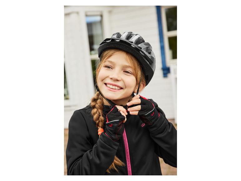 Fille en veste noire et gants, ajustant son casque de vélo