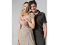 Une femme en robe beige et un homme en polo et pantalon vert foncé.