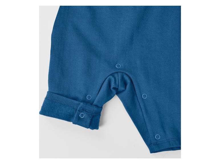 Grenouillère bébé bleue à boutons-pression, gros plan sur la jambe et l'entrejambe.