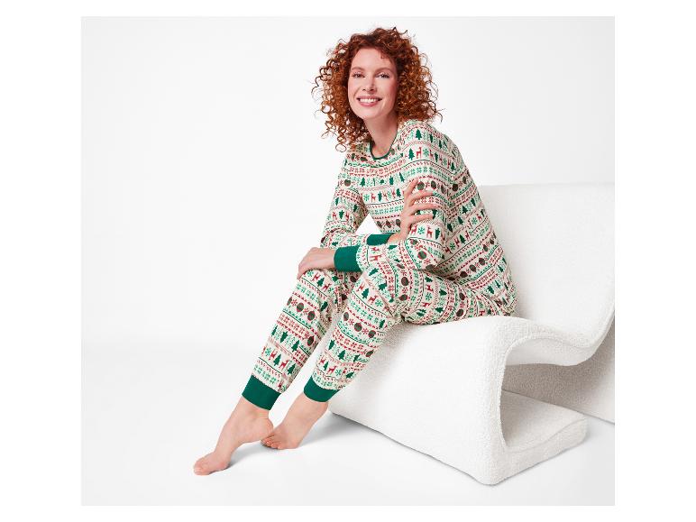 Femme souriante en pyjama de Noël, assise sur une chaise blanche