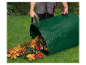 Un homme vide un sac de jardin rempli de feuilles d'automne.