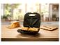 Sandwich grill et tranches de pain sur un comptoir de cuisine.