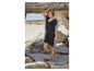 Une femme porte une robe de plage noire et blanche à rayures.