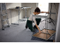 Femme assemblant une table de travail pliable dans un espace de construction.