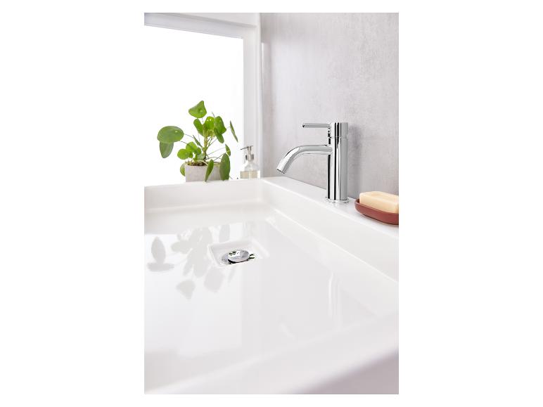 Un lavabo blanc avec un robinet chromé et un porte-savon.