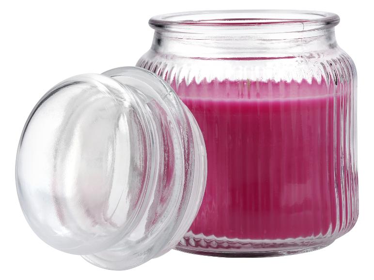 Bocal en verre ouvert avec une bougie parfumée rose.