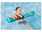 Femme se relaxant dans une piscine avec des flotteurs turquoise.