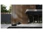 Terrasse moderne avec mur à lattes en bois, mobilier noir et plantes vertes.