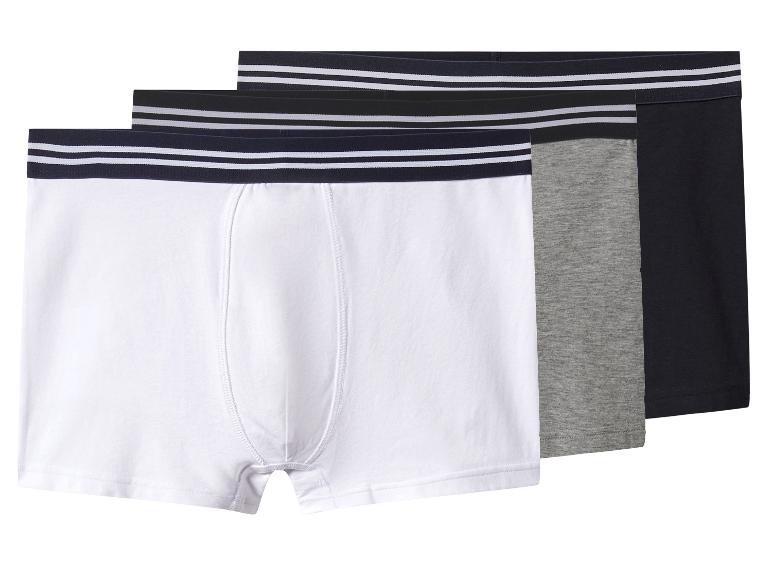 Trois boxers pour hommes en blanc, gris et noir avec des ceintures rayées.