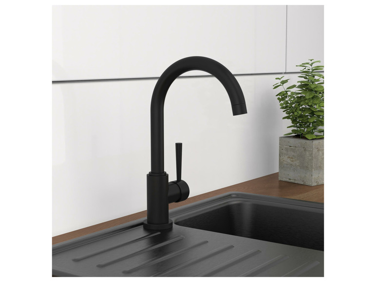 Un robinet de cuisine noir au-dessus d'un évier noir.