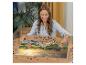 Une femme assemble un puzzle avec une image de paysage.