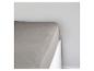 Un drap gris sur un lit blanc.