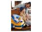 Un enfant avec un coussin de voyage Paw Patrol et un sac à roulettes.