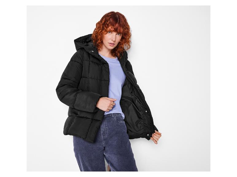 Femme rousse en doudoune noire et jean.