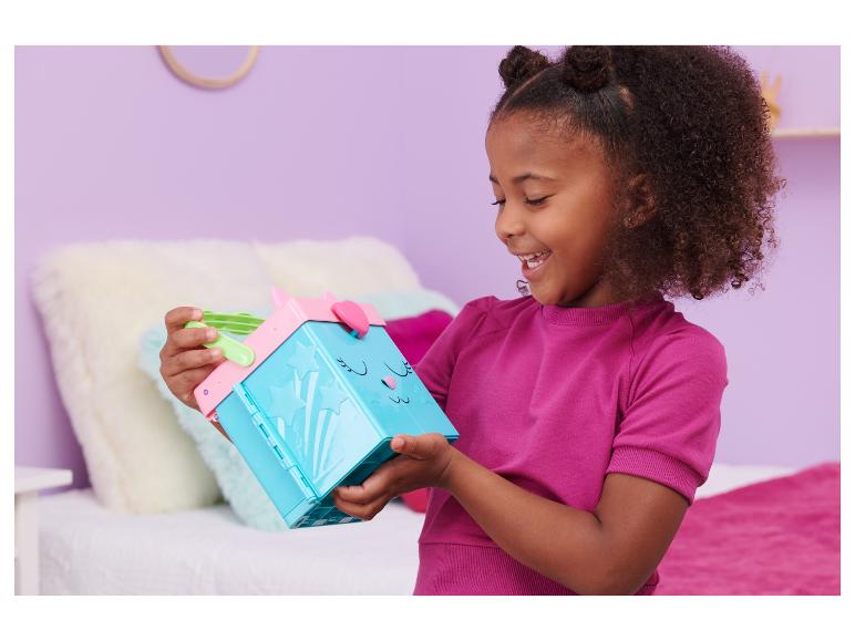 Fille heureuse tenant une boîte à jouets bleue et rose avec un visage de chat.