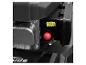 Gros plan sur un moteur de tondeuse à gazon noir avec un bouton d'amorçage rouge.