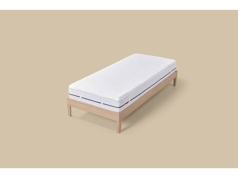 Lit simple avec cadre en bois et matelas blanc.
