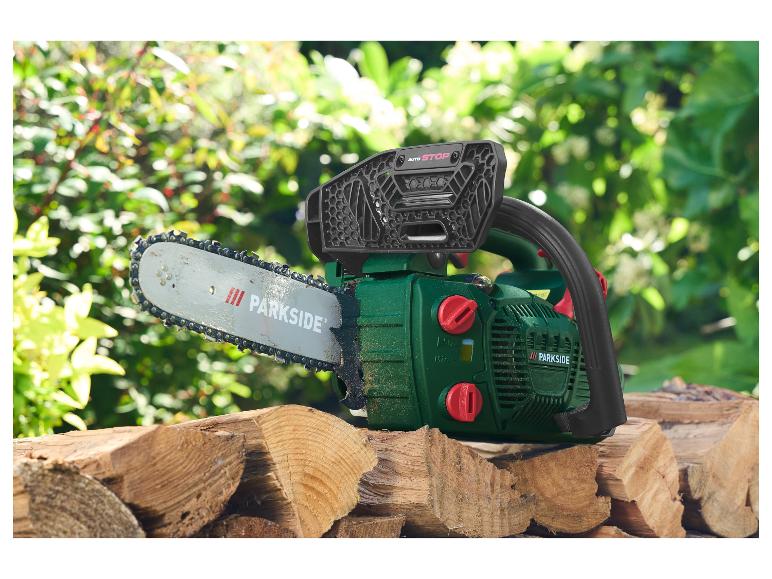 Tronçonneuse Parkside sur une pile de bois coupé dans un jardin.