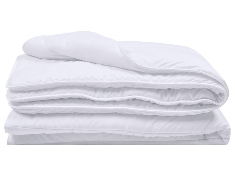 Couette blanche pliée avec bords cousus, isolée sur fond blanc