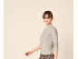 Femme en col roulé gris, lunettes de soleil et pantalon à motif léopard.