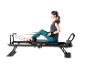 Femme s'entraînant sur un réformateur de pilates noir.
