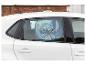 Une voiture blanche avec un pare-soleil Stitch à la fenêtre arrière.